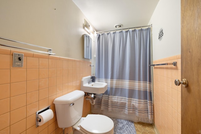 1200 9th St, Minot, ND 58703 - full bath featuring tile walls, toilet, a wainscoted wall, and a sink