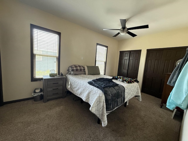 119 NW 6th St, Minot, ND 58703 - carpeted bedroom with multiple windows, two closets, a ceiling fan, and baseboards
