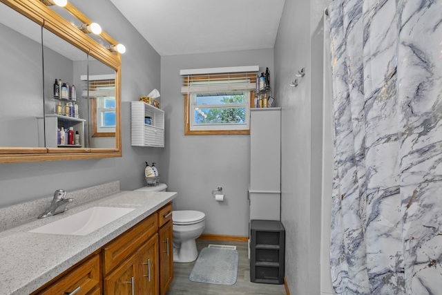 1213 Sunset Blvd, Minot, ND 58703 - bathroom featuring vanity, toilet, wood finished floors, a shower with shower curtain, and baseboards