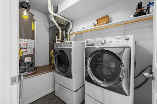 205 17th St, Minot, ND 58703 - washroom with water heater, washer and dryer, and dark tile patterned floors