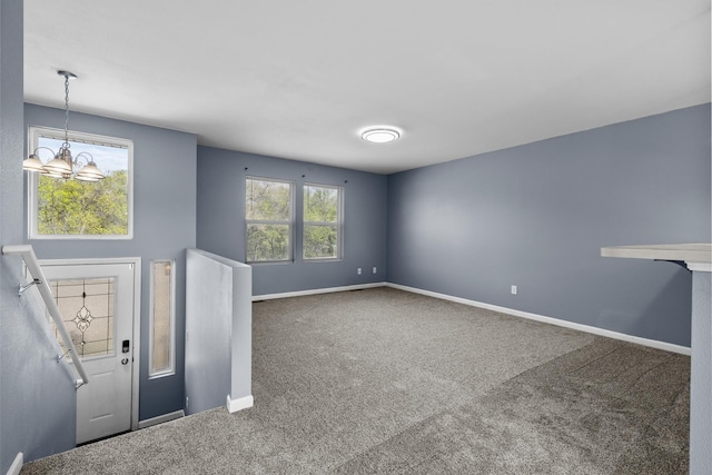 205 17th St, Minot, ND 58703 - entrance foyer featuring carpet, baseboards, and a chandelier