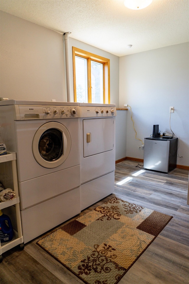 3700 10th Ave, Minot, ND 58701 - laundry area with washer and clothes dryer, wood finished floors, baseboards, and a textured ceiling