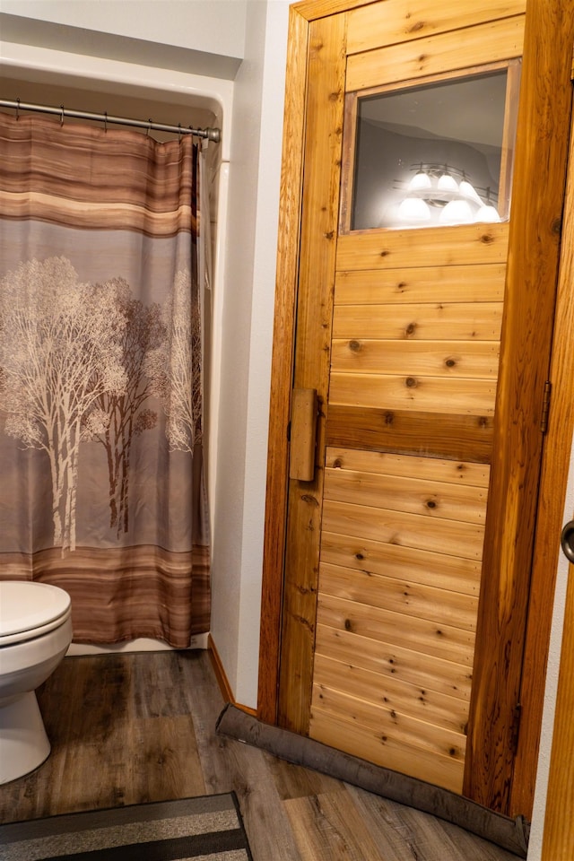 3700 10th Ave, Minot, ND 58701 - bathroom with wood finished floors, toilet, and curtained shower
