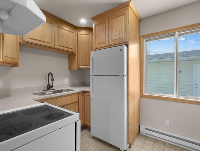 2301 2nd Ave Unit 2, Minot, ND 58701 - kitchen with white appliances, a baseboard heating unit, under cabinet range hood, a sink, and light countertops