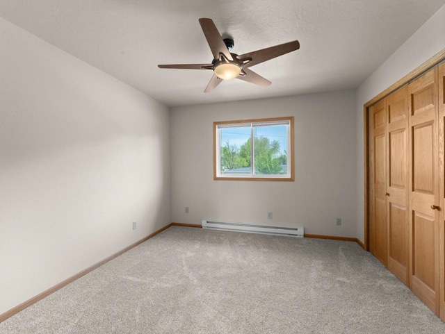 2301 2nd Ave Unit 2, Minot, ND 58701 - unfurnished bedroom featuring baseboard heating, carpet flooring, baseboards, and a closet