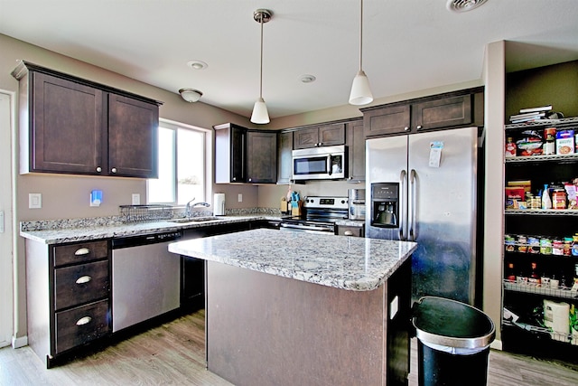 5304 15th Ave, Minot, ND 58701 - kitchen with appliances with stainless steel finishes, dark brown cabinetry, a sink, and light wood-type flooring