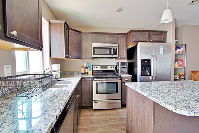 5304 15th Ave, Minot, ND 58701 - kitchen featuring stainless steel appliances, light wood-type flooring, dark brown cabinetry, and light stone counters