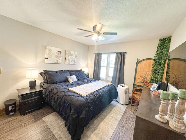101 6th St, Minot, ND 58703 - bedroom featuring light wood-style floors, a textured ceiling, and ceiling fan
