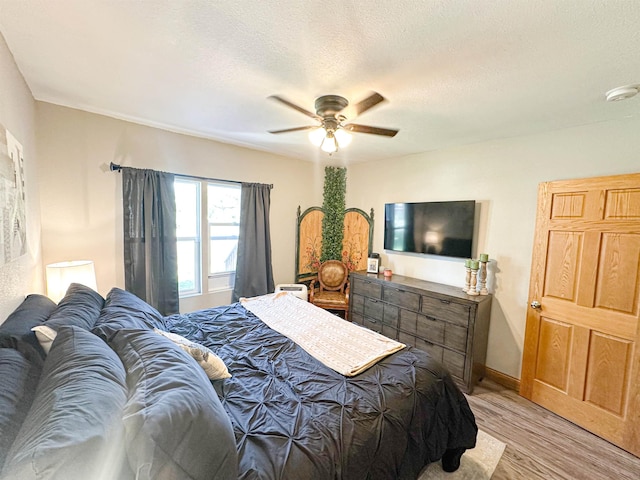 101 6th St, Minot, ND 58703 - bedroom with light wood-type flooring, ceiling fan, a textured ceiling, and baseboards