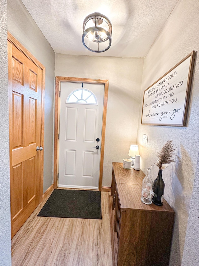 101 6th St, Minot, ND 58703 - foyer entrance featuring light wood finished floors, a textured ceiling, and baseboards