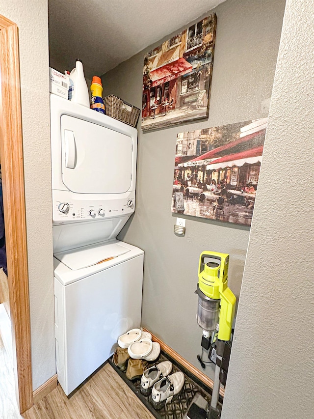 101 6th St, Minot, ND 58703 - washroom featuring stacked washing machine and dryer, wood finished floors, and a textured wall