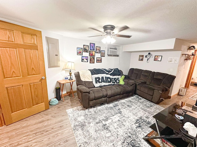 101 6th St, Minot, ND 58703 - living room featuring electric panel, light wood-type flooring, ceiling fan, a textured ceiling, and baseboards