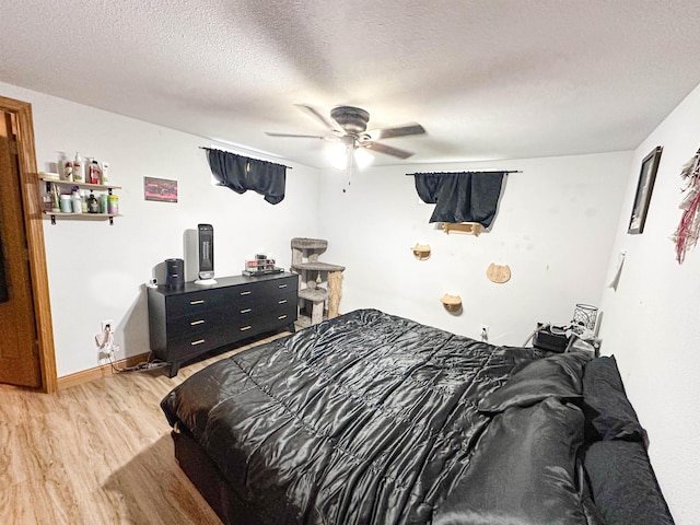 101 6th St, Minot, ND 58703 - bedroom featuring light wood finished floors, ceiling fan, and a textured ceiling
