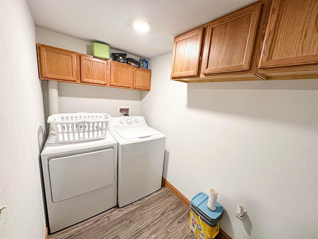 101 6th St, Minot, ND 58703 - laundry area featuring cabinet space, light wood-style floors, independent washer and dryer, and baseboards