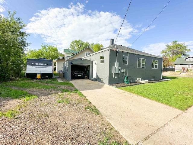 101 6th St, Minot, ND 58703 - view of property exterior with stucco siding, concrete driveway, a yard, and an attached garage