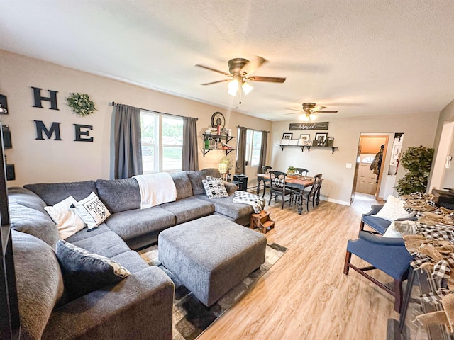 101 6th St, Minot, ND 58703 - living room featuring a ceiling fan, light wood-style floors, a textured ceiling, and baseboards
