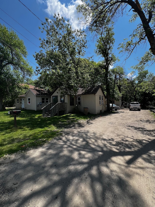 622 Central Ave, Minot, ND 58701 - view of side of property featuring a lawn, driveway, and stucco siding