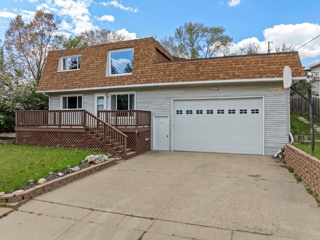 1127 8th St, Minot, ND 58703 - view of front of house with a shingled roof, concrete driveway, a deck, and mansard roof