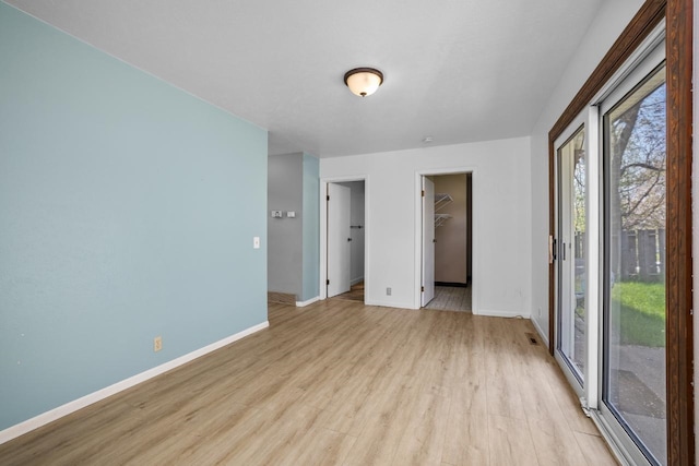 1127 8th St, Minot, ND 58703 - empty room with light wood-style flooring and baseboards