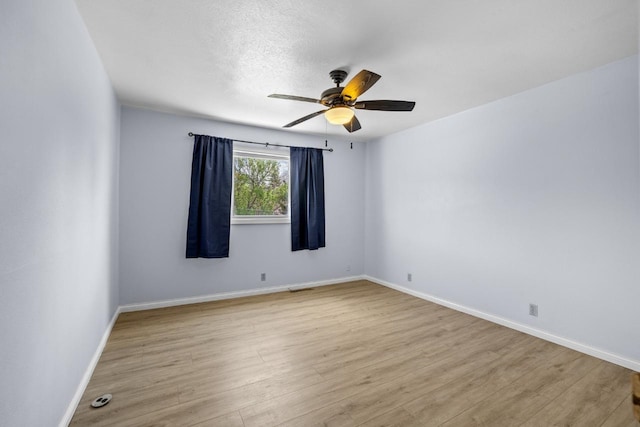 1127 8th St, Minot, ND 58703 - empty room with ceiling fan, wood finished floors, and baseboards