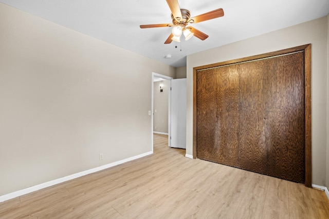 1127 8th St, Minot, ND 58703 - unfurnished bedroom with baseboards, light wood-style flooring, a closet, and ceiling fan
