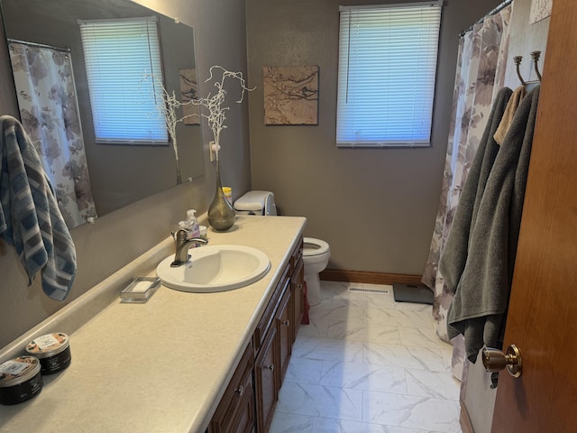 1130 8th St, Minot, ND 58703 - bathroom with marble look tiles, vanity, toilet, and a shower with curtain