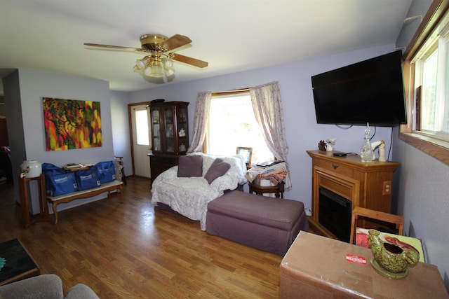 506 W Ave, Granville, ND 58741 - living room featuring wood finished floors, ceiling fan, and a fireplace