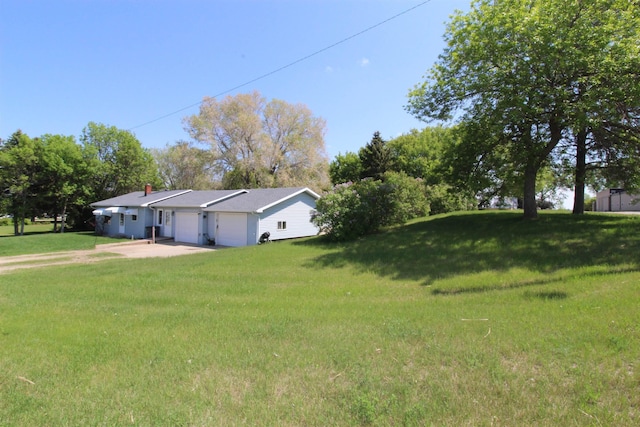 506 W Ave, Granville, ND 58741 - view of grassy yard featuring an attached garage and concrete driveway