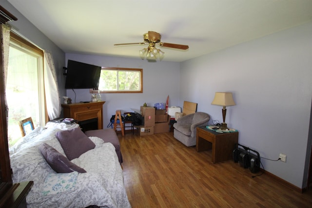 506 W Ave, Granville, ND 58741 - living area featuring wood finished floors, a ceiling fan, and a fireplace