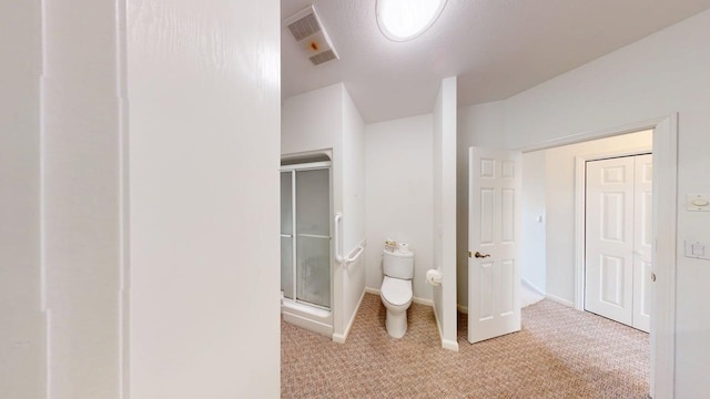 2700 18th Ave, Minot, ND 58701 - bathroom featuring a stall shower, toilet, baseboards, and carpet floors