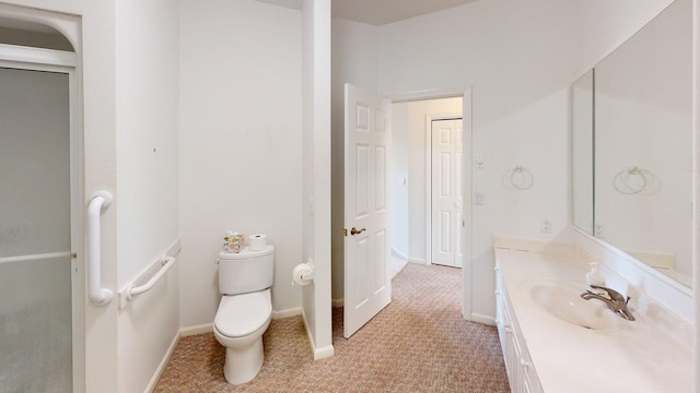 2700 18th Ave, Minot, ND 58701 - bathroom featuring vanity, toilet, and baseboards