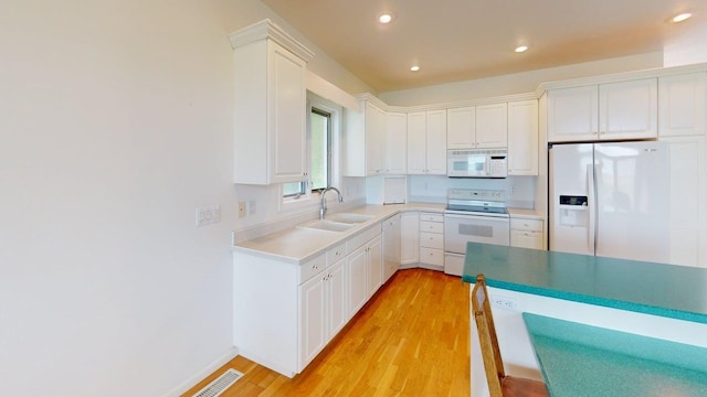 2700 18th Ave, Minot, ND 58701 - kitchen featuring white appliances, light wood-style floors, recessed lighting, a sink, and white cabinetry
