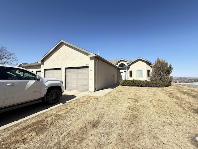 2700 18th Ave, Minot, ND 58701 - view of front facade with a garage, driveway, and stucco siding