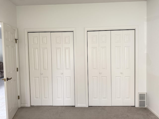 2700 18th Ave, Minot, ND 58701 - unfurnished bedroom featuring carpet floors, multiple closets, and baseboards