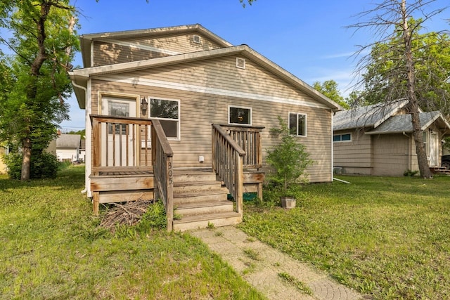 305 6th St, Minot, ND 58703 - rear view of property featuring a yard and a deck