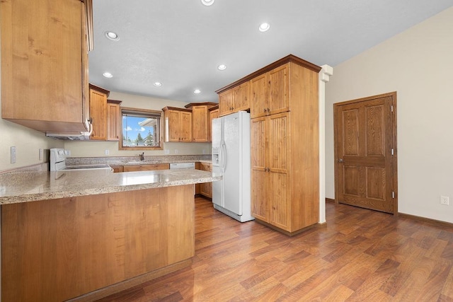 1600 16th St, Minot, ND 58701 - kitchen featuring white appliances, a peninsula, dark wood-style flooring, recessed lighting, and a sink