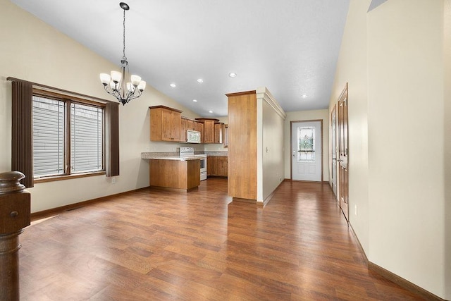 1600 16th St, Minot, ND 58701 - kitchen with white appliances, brown cabinets, a peninsula, dark wood-style floors, and a chandelier