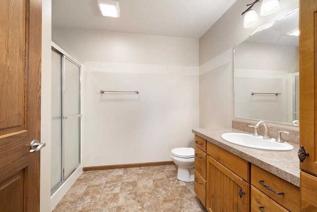 1600 16th St, Minot, ND 58701 - full bathroom featuring vanity, toilet, a shower with door, and baseboards