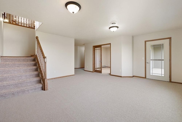 1600 16th St, Minot, ND 58701 - unfurnished living room with light colored carpet, baseboards, and stairs