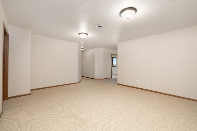 1600 16th St, Minot, ND 58701 - spare room featuring light colored carpet, baseboards, and a textured ceiling