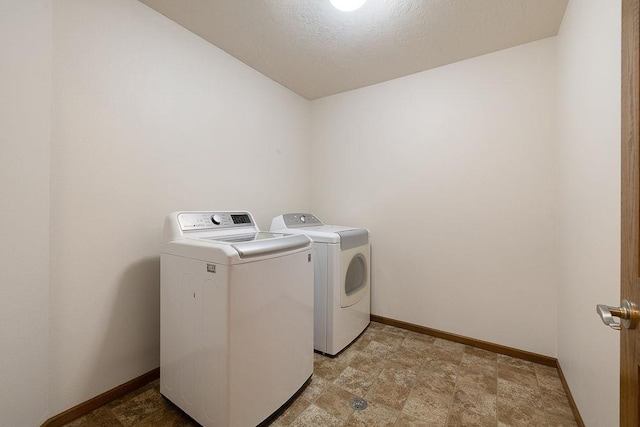 1600 16th St, Minot, ND 58701 - washroom with washing machine and clothes dryer, baseboards, and stone finish floors