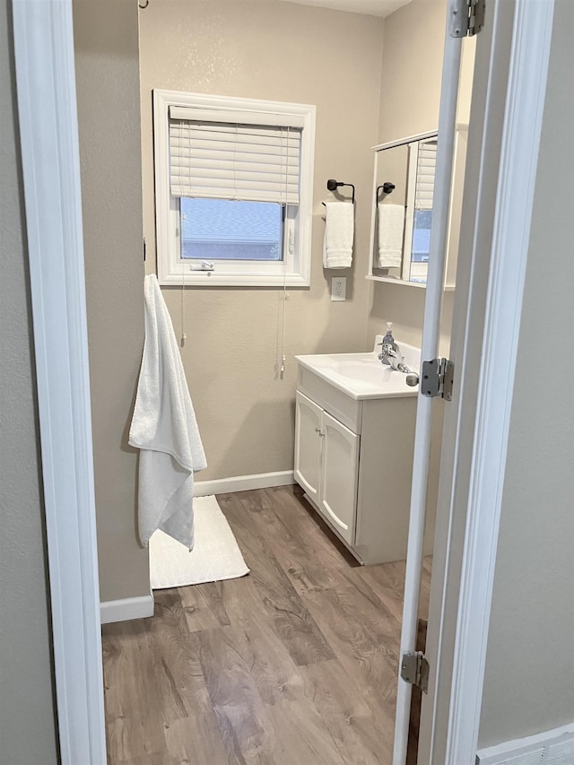 430 NW 2nd Ave, Minot, ND 58703 - bathroom featuring vanity, wood finished floors, and baseboards