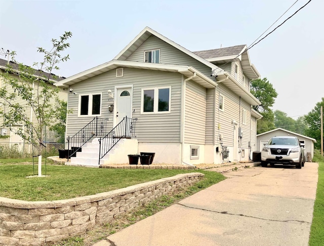 430 NW 2nd Ave, Minot, ND 58703 - view of front facade with a detached garage, a front yard, driveway, and an outbuilding