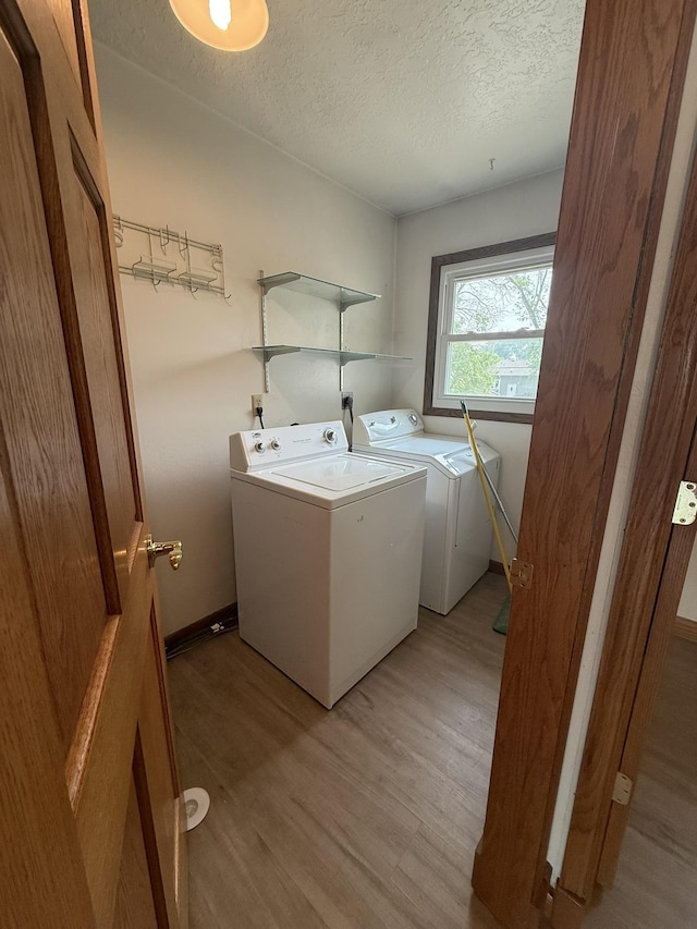619 25th Ave, Minot, ND 58703 - laundry area with washing machine and clothes dryer, a textured ceiling, and light wood-style flooring