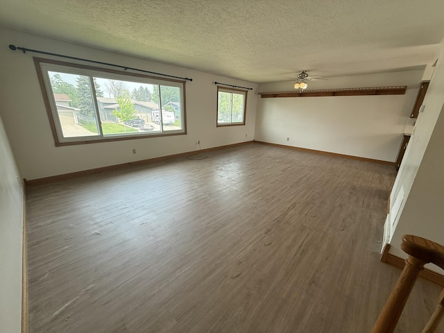 619 25th Ave, Minot, ND 58703 - empty room featuring wood finished floors, baseboards, a ceiling fan, and a textured ceiling