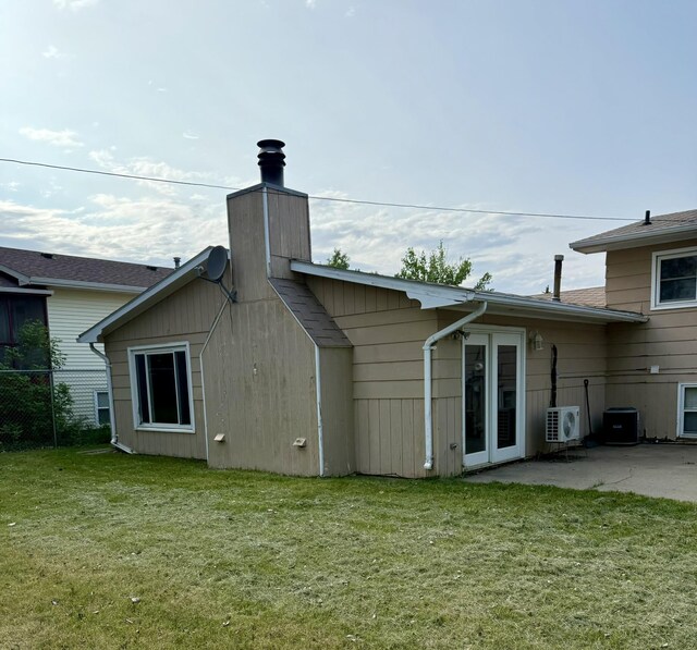619 25th Ave, Minot, ND 58703 - rear view of property featuring a chimney, ac unit, and a patio area
