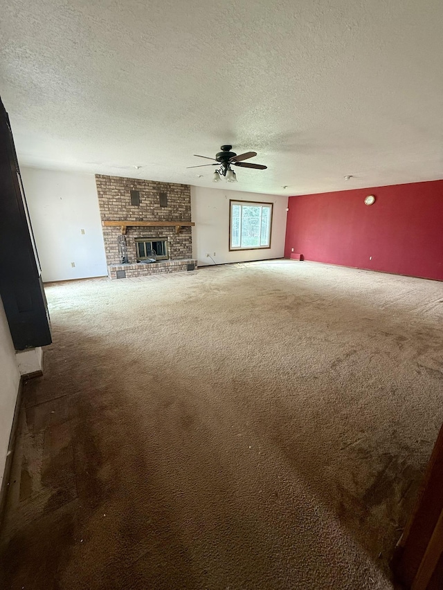 619 25th Ave, Minot, ND 58703 - unfurnished living room with carpet flooring, a ceiling fan, a textured ceiling, and a brick fireplace