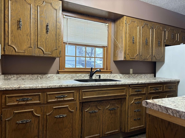 1107 SE 2nd St, Minot, ND 58701 - kitchen with freestanding refrigerator, a sink, and light countertops