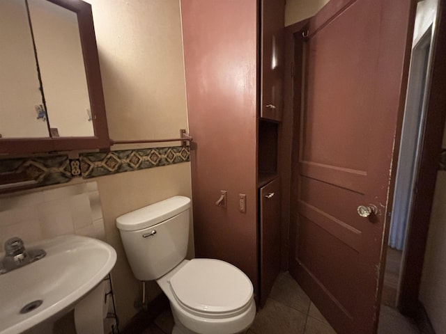 1107 SE 2nd St, Minot, ND 58701 - half bath with a sink, toilet, and tile patterned floors