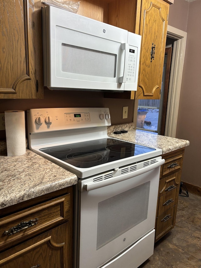 1107 SE 2nd St, Minot, ND 58701 - kitchen with white appliances, light countertops, and brown cabinetry